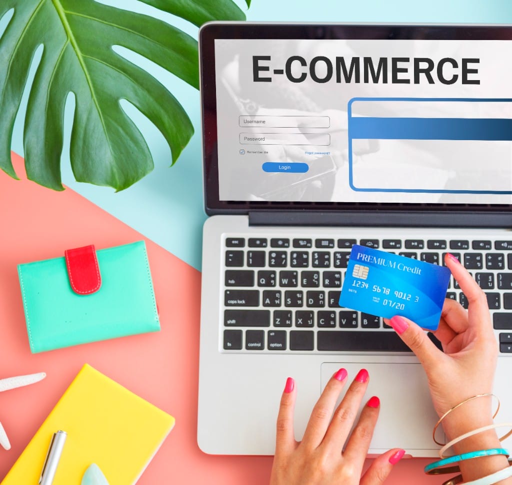 Top-down view of a person making a secure online payment on a laptop with a credit card for ecommerce checkout